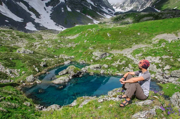 Young man admires the mountain lake. — Stock Photo, Image