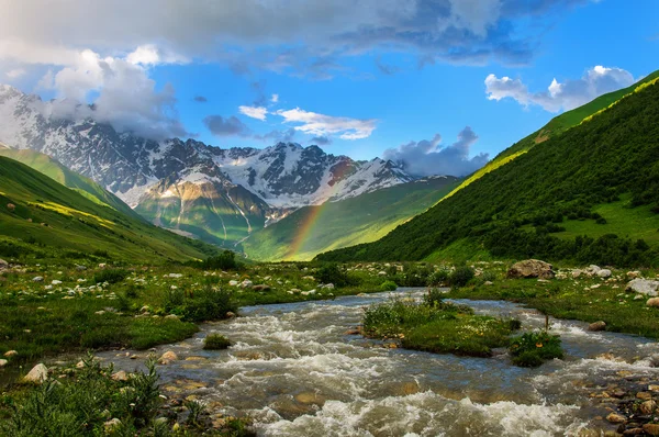 Gökkuşağının üstünde hızlı nehir ve karla kaplı dağlar. Gürcistan — Stok fotoğraf