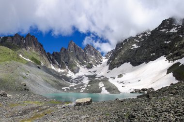 Kayalarda bir kayanın altında ağır güzel göl.