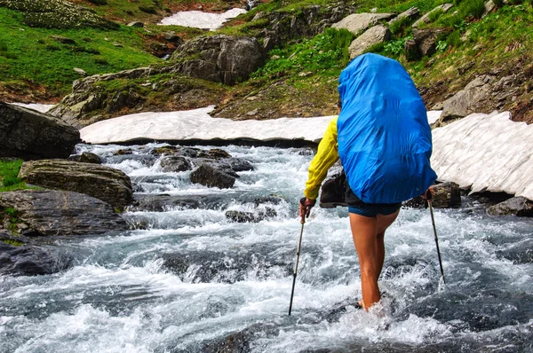 The tourist with a big backpack crossing river ford. — Stock Photo, Image