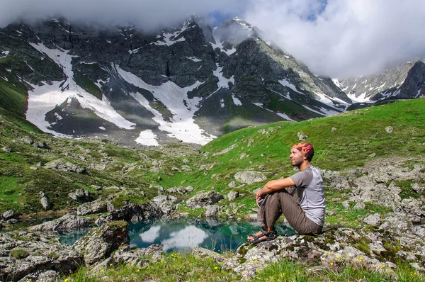 Young man admires the mountain lake. — Stock Photo, Image