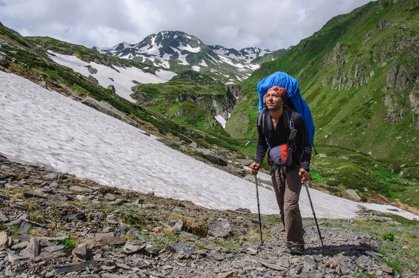 Jeune touriste avec un grand sac à dos montant dans les montagnes — Photo