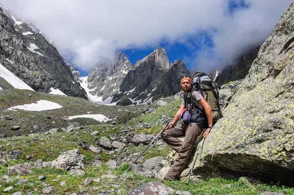 Mladý turista s velkým batohem stoupáme v horách — Stock fotografie