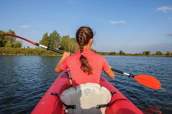 一个穿着鲜艳衣服的年轻女子在河边的一艘红色皮划艇上漂浮着 乌克兰 — 图库照片