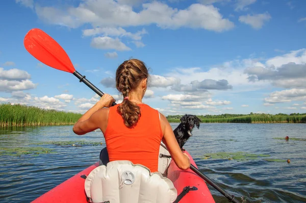 一个年轻的女运动员带着一只黑狗科克 斯皮尔在Zdwyzh河上漂流 乌克兰 — 图库照片
