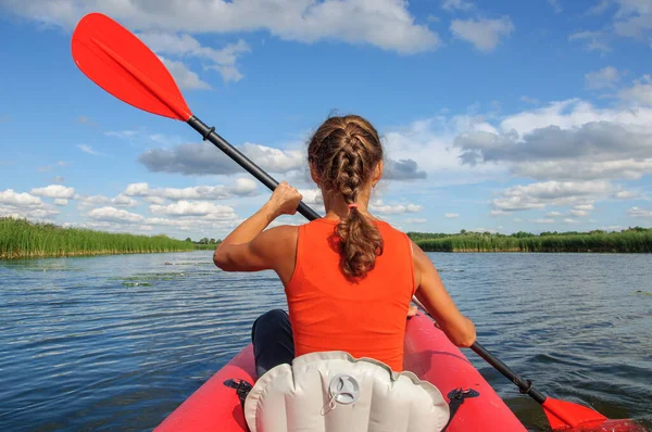 若いスポーツの女の子が黒い犬のコッカー スパニエルと赤いカヤックに乗ってズウィディジ川に浮かんでいます ウクライナ ストックフォト