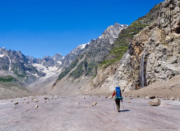 Lone tourist goes to the mountain waterfall — Stock Photo, Image