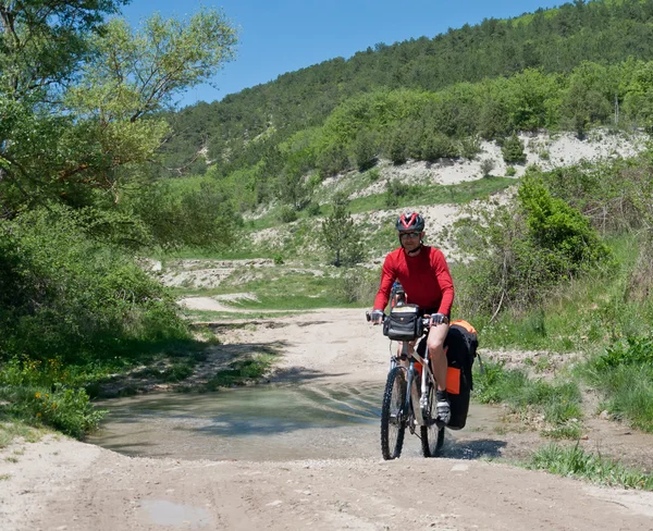 Ciclista montando na serpentina de montanha — Fotografia de Stock