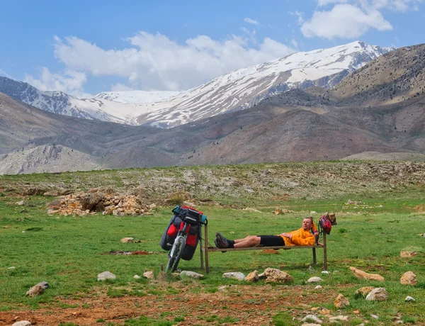 Jeune cycliste touristique couché au repos dans les hautes montagnes — Photo