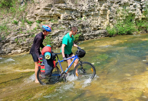 Deux cyclistes ont traversé une rivière de montagne à vélo — Photo