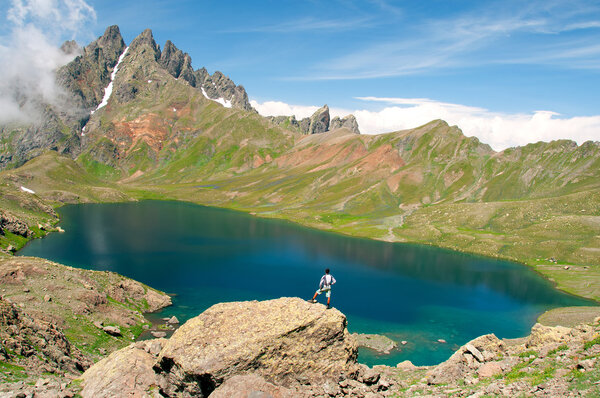 Человек любуется красивым озером в горах
