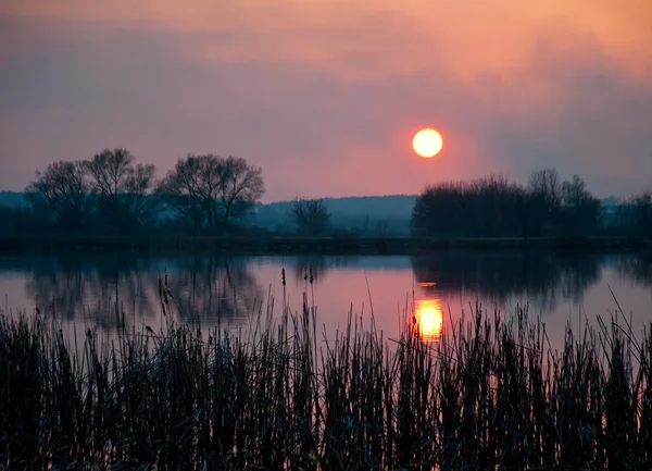 Magischer Sonnenuntergang über dem See im Dorf. — Stockfoto