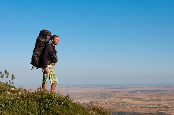 Турист стоит на холме и смотрит вниз — стоковое фото