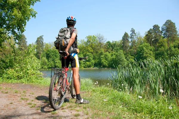 Ciclista de montaña al lado de un hermoso lago — Foto de Stock