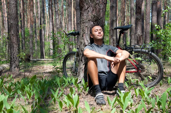 Avkopplande cyklist i barrskogen våren under tall träd — Stockfoto