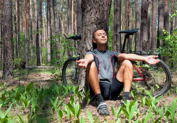 Avkopplande cyklist i barrskogen våren under tall träd — Stockfoto