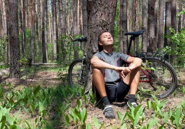 Bicycliste relaxant dans la forêt de conifères le printemps sous le pin — Photo