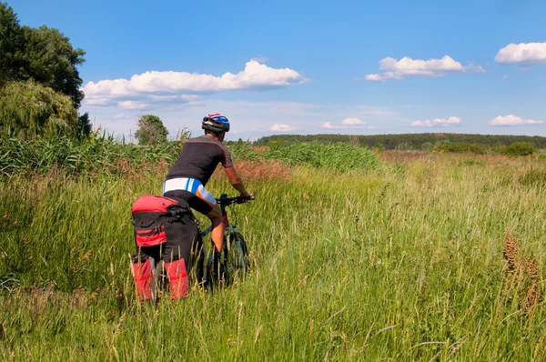 Ciclista de montaña junto a un hermoso río — Foto de Stock