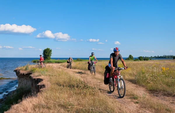 Group of tourists  mountain bike ride on dirt road. Stock Image