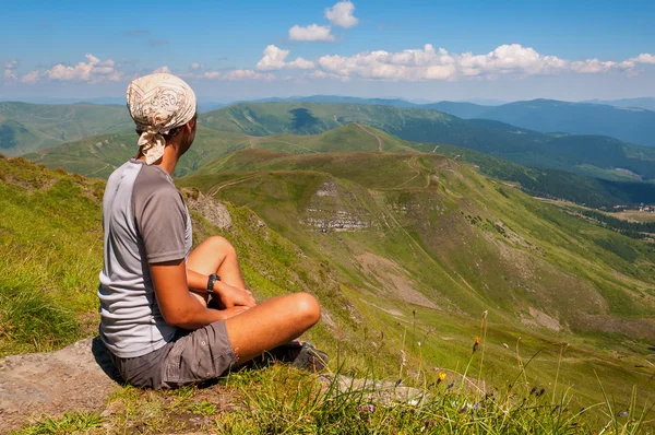 Junge Touristen ruhen auf dem Gipfel mit Blick auf das Tal — Stockfoto