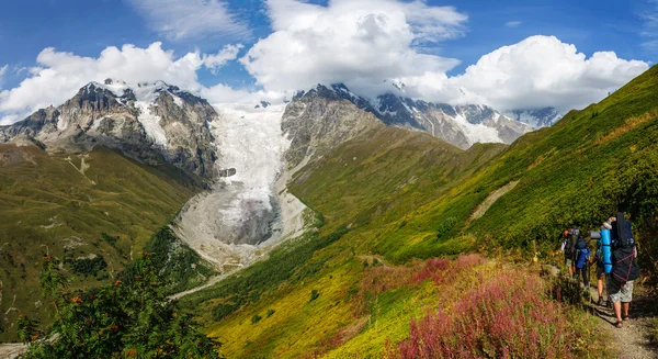 A turisták a gyönyörű gleccser Ladaar táj Grúziában. — Stock Fotó