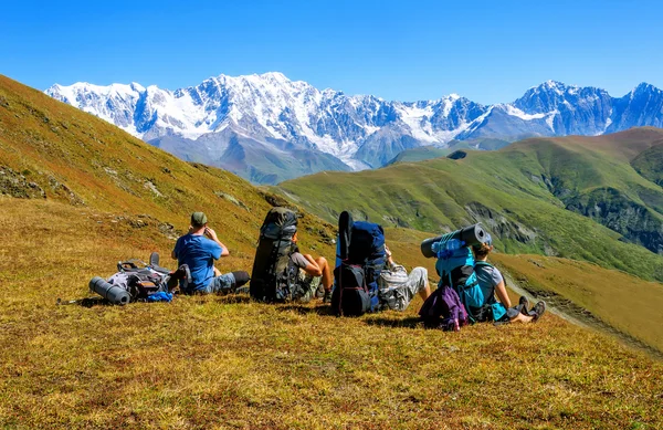 Группа туристов с большими рюкзаками отдыхает на горе — стоковое фото