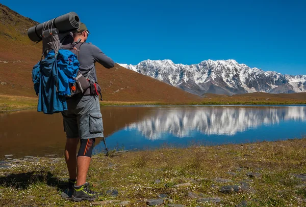 Caminante fotógrafo tomando fotos del lago en las montañas — Foto de Stock