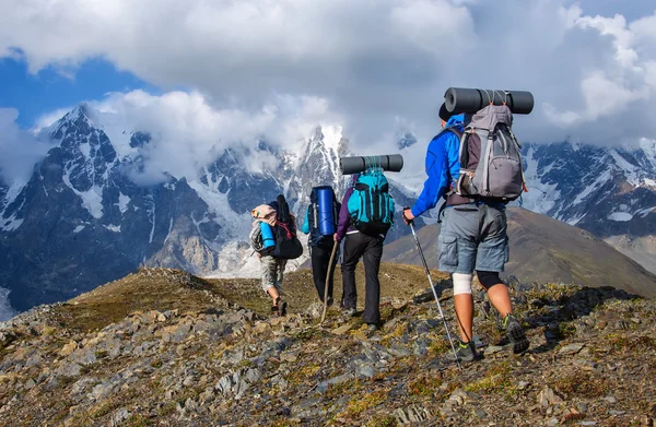 Büyük sırt çantaları turistlerle gruptur dağda — Stok fotoğraf