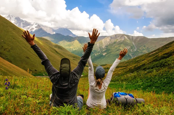 Group of tourists with large backpacks relax on mountain Stock Photo