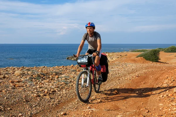 Homme va plage de sable sur le vélo de montagne avec grand sac à dos . — Photo