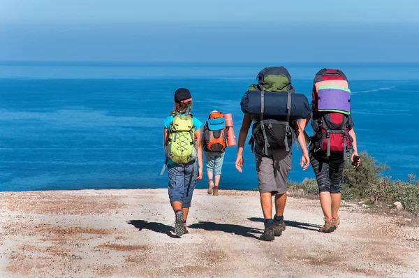 Família com grandes mochilas estão no mar de estrada — Fotografia de Stock