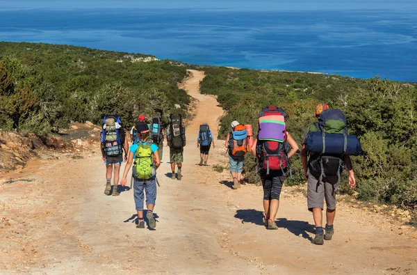 Büyük sırt çantaları turistlerle gruptur yol denizde — Stok fotoğraf