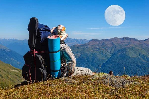 Caminante cansado se relaja en una pendiente en las montañas — Foto de Stock