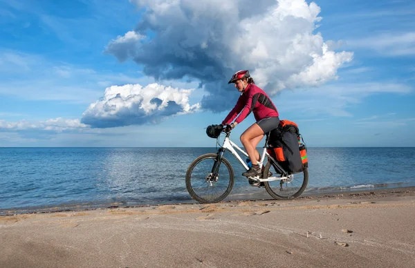 Woman bike riding on bank of Mediterranean Sea — Stock Photo, Image
