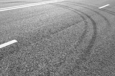 Satırları beyaz çizgili ve lastik izleri işaretleme ile asfalt yol