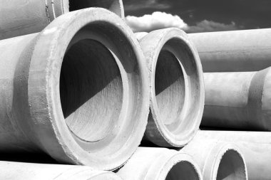 Endüstriyel beton drenaj boruları inşaat için yığılmış. Yeni tüpler siyah ve beyaz