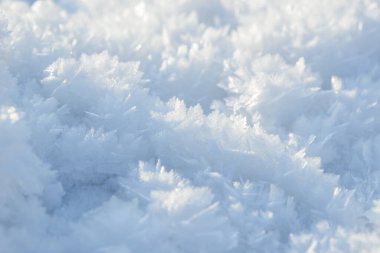İstiflenmiş arkaplan dokusu. Taze buz ve kar zemini, kar taneleri ve tepecikleriyle. Mevsimlik duvar kâğıdı. Donmuş su geometrik şekiller ve şekiller. Soğuk hava atmosferik yağış.