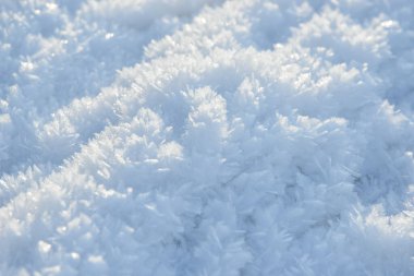 İstiflenmiş arkaplan dokusu. Taze buz ve kar zemini, kar taneleri ve tepecikleriyle. Mevsimlik duvar kâğıdı. Donmuş su geometrik şekiller ve şekiller. Soğuk hava atmosferik yağış.