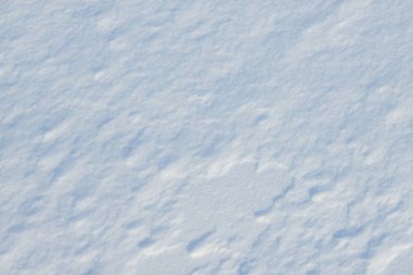 Temiz, beyaz arka plan dokusu. Kar taneleri ve kar yığınlarıyla kışın arka planda. Kar yığınları. Mevsimlik manzara ayrıntıları.
