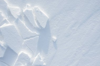 Temiz, beyaz arka plan dokusu. Kar taneleri ve kar yığınlarıyla kışın arka planda. Kar yığınları. Mevsimlik manzara ayrıntıları.