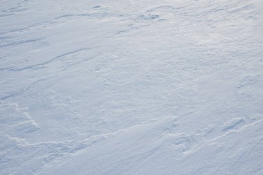 Temiz, beyaz arka plan dokusu. Kar taneleri ve kar yığınlarıyla kışın arka planda. Kar yığınları. Mevsimlik manzara ayrıntıları.