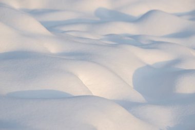 Temiz, beyaz arka plan dokusu. Kar taneleri ve kar yığınlarıyla kışın arka planda. Kar yığınları. Mevsimlik manzara ayrıntıları.