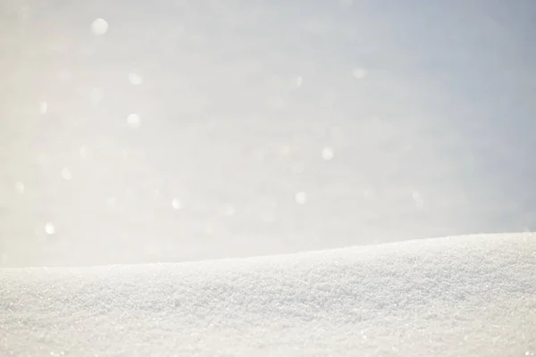 Fresh clean white snow background texture. Winter background with snowflakes and snow mounds. Snow lumps. Seasonal landscape details. Soft beautiful bokeh.