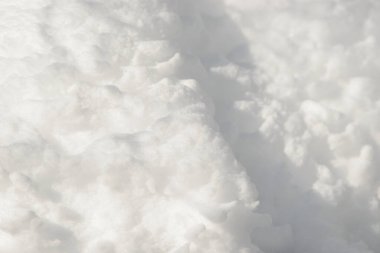 Temiz, beyaz arka plan dokusu. Kış arka planında donmuş kar taneleri ve kar yığınları var. Kar yığınları. Mevsimlik manzara detayları. Soğuk hava.