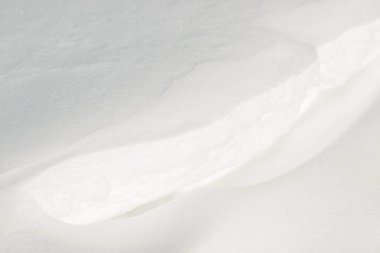 Temiz, beyaz arka plan dokusu. Kış arka planında donmuş kar taneleri ve kar yığınları var. Kar yığınları. Mevsimlik manzara detayları. Soğuk hava.