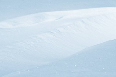 Temiz, beyaz arka plan dokusu. Kış arka planında donmuş kar taneleri ve kar yığınları var. Kar yığınları. Mevsimlik manzara detayları. Soğuk hava.