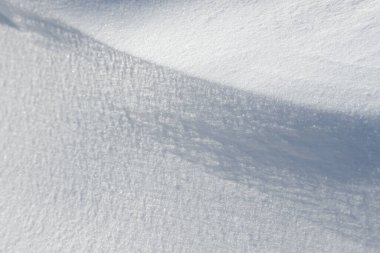 Temiz, beyaz arka plan dokusu. Kış arka planında donmuş kar taneleri ve kar yığınları var. Kar yığınları. Mevsimlik manzara detayları. Soğuk hava.