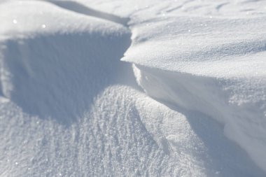 Temiz, beyaz arka plan dokusu. Kış arka planında donmuş kar taneleri ve kar yığınları var. Kar yığınları. Mevsimlik manzara detayları. Soğuk hava.