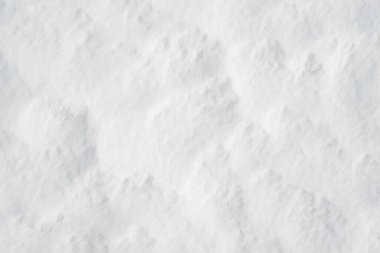 Temiz, beyaz arka plan dokusu. Kış arka planında donmuş kar taneleri ve kar yığınları var. Kar yığınları. Mevsimlik manzara detayları. Soğuk hava.