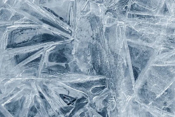 Ice background texture. Frozen water in various geometric abstract shapes. Seasonal natural effect. Cold weather. The surface of the winter water reservoir.